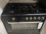 a black stove in a kitchen with a tiled floor