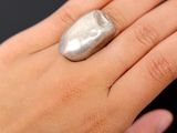 la main d'une femme à laquelle est passée une bague en argent