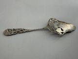 silver plated spoon on a white surface with a silver handle