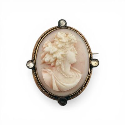 a close up of a broochle of a woman with a flower in her hair