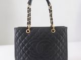 un sac Chanel noir muni d'une poignée en chaîne dorée