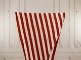 un grand drapeau rayé de rouge et de blanc suspendu à une corde