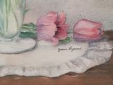 three pink tulips in a white vase on a table
