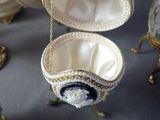 a white and blue egg with a chain hanging from it
