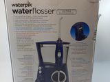 a blue water flosser in the box on the table