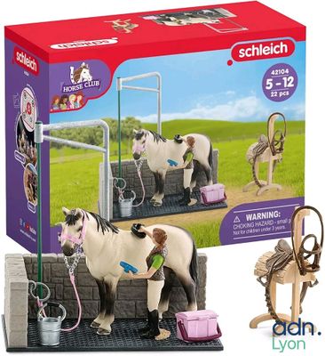 toy horses are standing in a stable with a horse on the ground