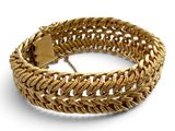 gros plan d'un bracelet en or sur fond blanc