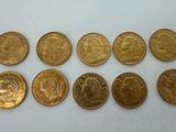 a bunch of gold coins sitting on top of a white surface