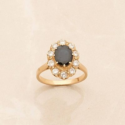 a gold ring with a black stone surrounded by white diamonds