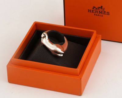 an orange box with a silver ring inside of it on a white surface