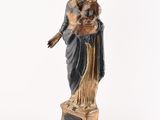 an old statue of a woman holding a child on a pedestal
