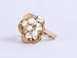 a close up of a gold ring with pearls on a white background