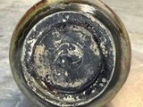 a close up of a dirty glass bottle on a table