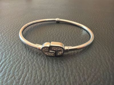 un bracelet en argent orné de pierres marron sur un bracelet en cuir noir