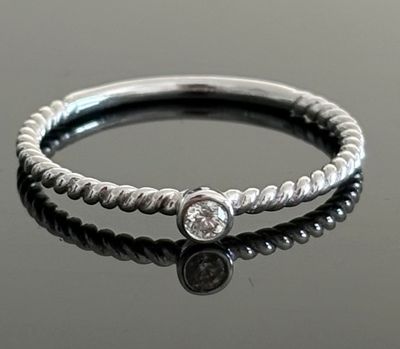 Gros plan sur une bague en argent ornée d'un diamant
