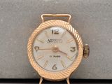 a gold watch with a white face sitting on top of a table