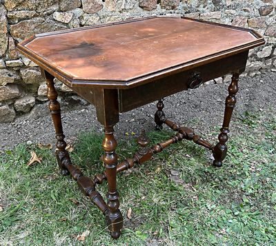 une petite table avec un plateau en bois posée dans l'herbe