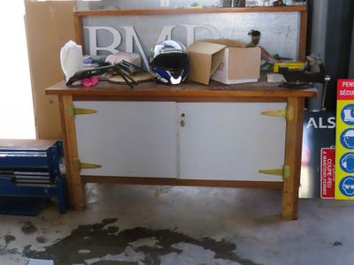 un établi dans un garage, sur lequel sont posées de nombreuses boîtes