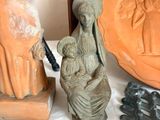 a statue of a woman holding a child next to a statue of a man