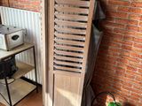 a stack of wooden shutters next to a brick wall