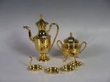 three pieces of gold plated tea and coffee set on a white surface