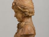 a wooden bust of a woman on a shelf