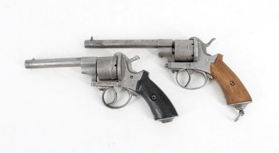 two revolvers are shown on a white surface with a wooden handle