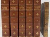 six vieux livres sont alignés sur une surface blanche