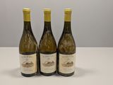 trois bouteilles de vin posées sur une table blanche