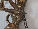 a brass bell hanging from a chain on a marble table