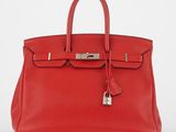 un sac à main en cuir rouge muni d'un cadenas sur la poignée