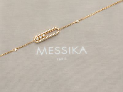 un collier plaqué or composé d'une barre ornée de perles montée sur une chaîne en or