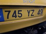 a close up of a yellow car with the number plate on it