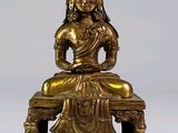 une image représentant une statue en or d'une personne assise sur un banc