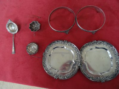 deux assiettes en argent et deux cuillères posées sur une nappe rouge