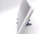 a tablet computer sitting on a stand on a white surface