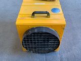 a yellow heater sitting on the ground next to a sign