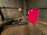 un réfrigérateur rouge et des tuyaux dans une pièce où se trouve une armoire rouge