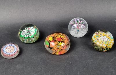 six different colored glass marbles sitting on top of a black surface