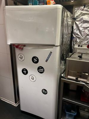 un réfrigérateur blanc dans une cuisine, à côté d'une cuisinière