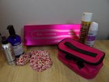 a pink bag sitting on top of a table next to a bottle of lotion