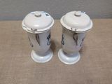 two salt and pepper shakers sitting on a table