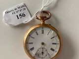 a gold pocket watch hanging on a wall with a price tag