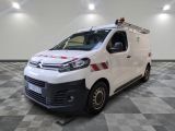 la camionnette blanche est garée dans une grande pièce au sol en damier