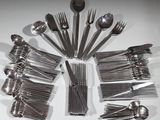de nombreuses fourchettes et cuillères disposées sur la table