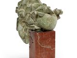une sculpture représentant une tête de chou posée sur un bloc de bois