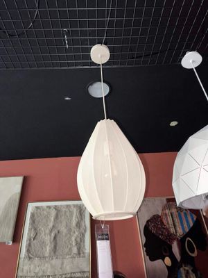 trois lampes blanches suspendues au plafond dans une pièce