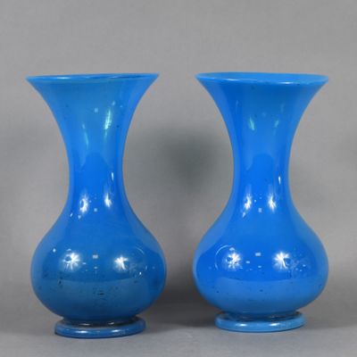 pair of blue glass vases sitting on top of a table