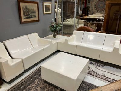 a picture of a living room with a white couch and ottoman