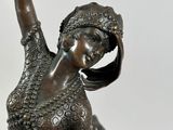 bronze statue of a woman holding a fan on a marble base